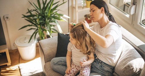 Mère coiffant les cheveux de sa fille dans le salon