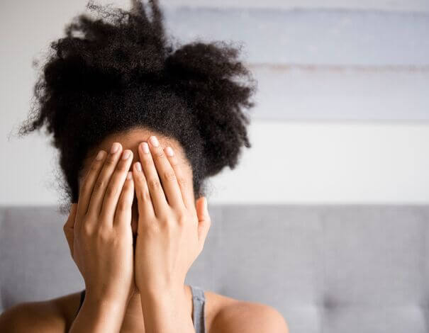 Femme qui cache son visage avec ses mains