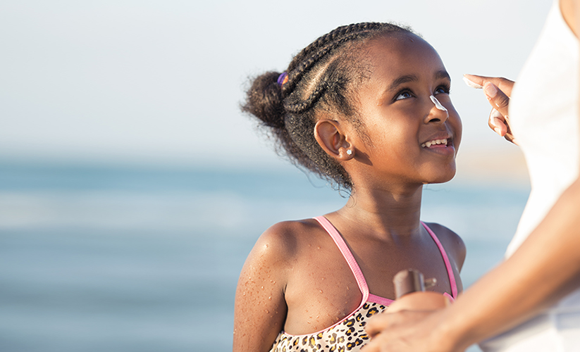 mother put sunscreen on daughter 